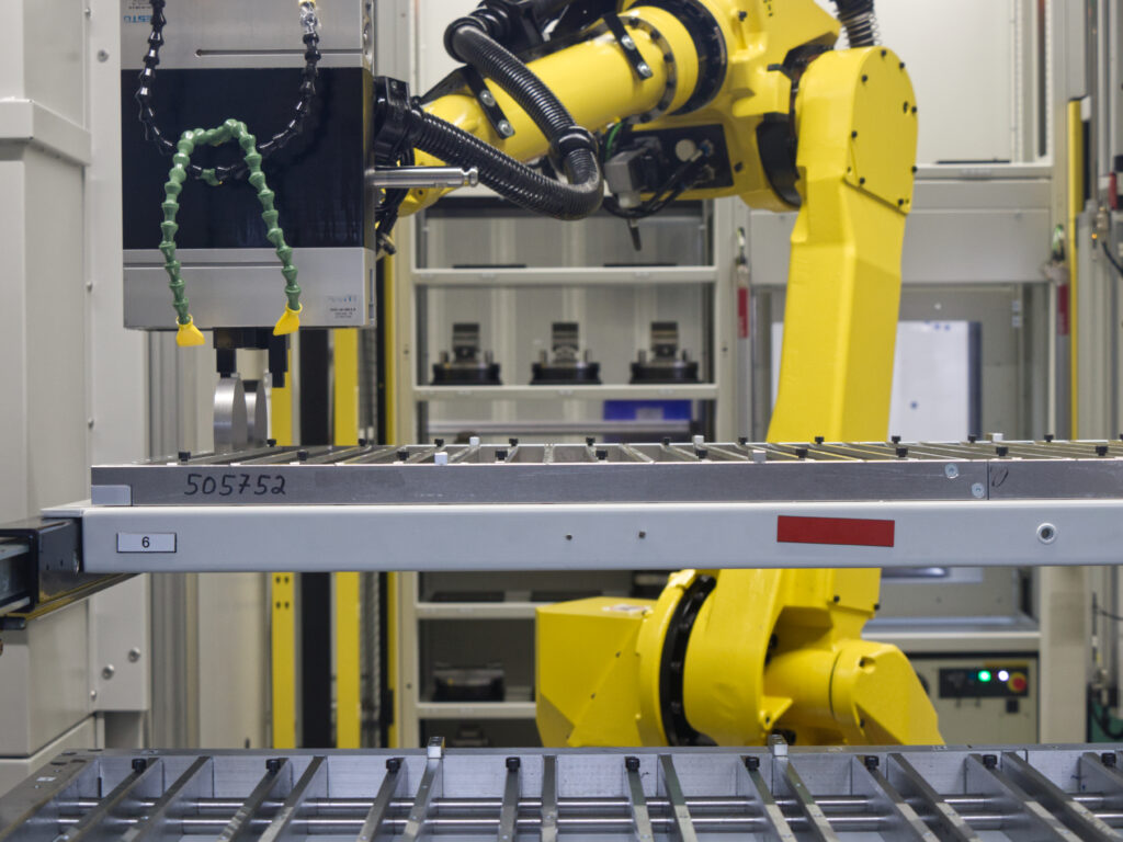 Maßgeschneiderte Lösung für komplexe Teile: Der Roboter positioniert rundgesägte Rohlinge exakt für die Bearbeitung.